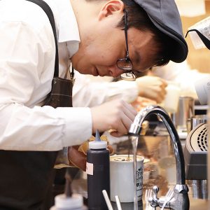 라떼 기술을 시연하고 있는 바리스타의 모습 라떼 기술을 시연하고 있는 바리스타의 모습