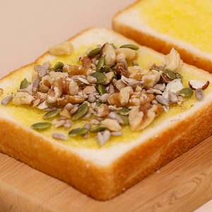 소스를 바른 식빵에 견과류를 뿌려주세요